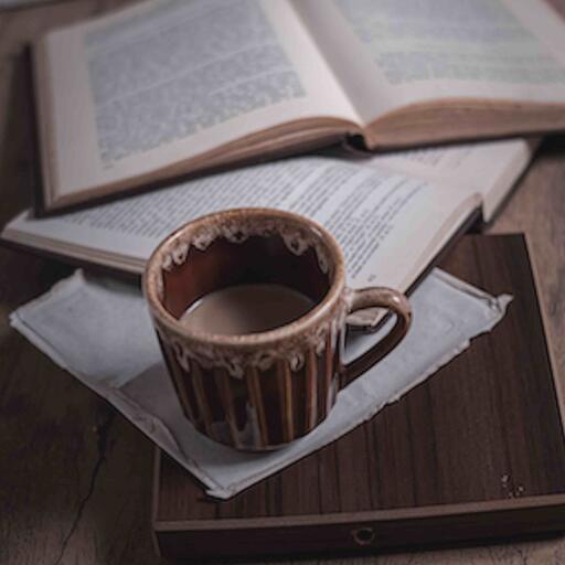A coffee cup on an open book, processed by the Enlace machine: the blurry photo they sent by mms