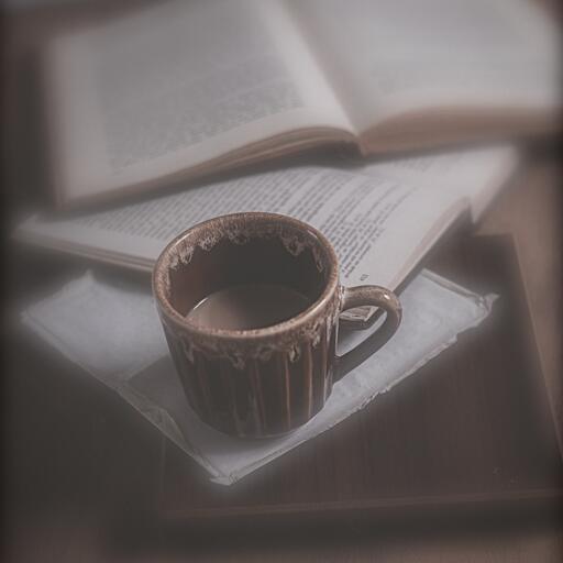 A coffee cup on an open book, processed by the Gaviota machine: sharp center, dreamy edges